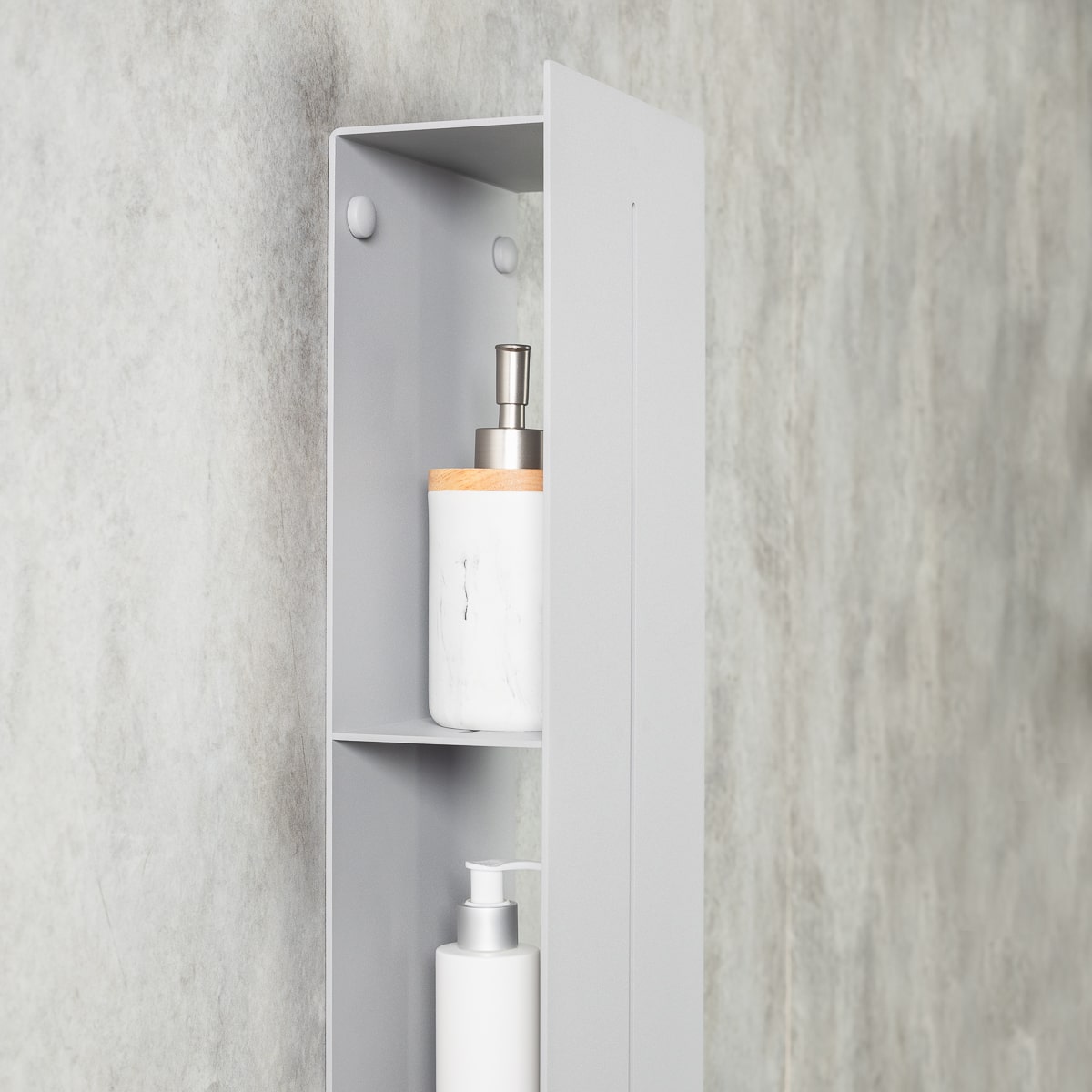  a close-up of a gray vertical organizer with three hidden shelves. The shelves are partially revealed,  the organizer is mounted on a textured gray wall, creating a sleek and modern look